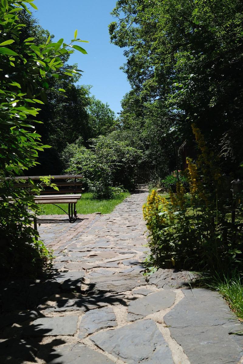 Bruchsteinweg durch den Garten zu einer Bank im Grünen